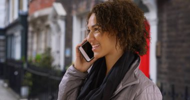 Oldukça siyah bin yıllık kız mutlu evinin önünde taşınabilir aygıtta sohbetleri.