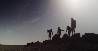 Sahilde büyük kayaları keşfetmek arkadaşlar