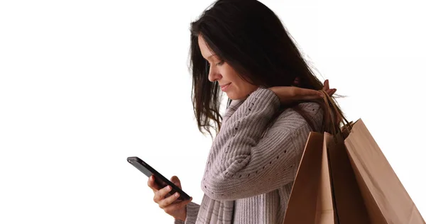 Duizendjarige Vrouw Texting Terwijl Uitvoering Van Boodschappentassen Witte Achtergrond — Stockfoto