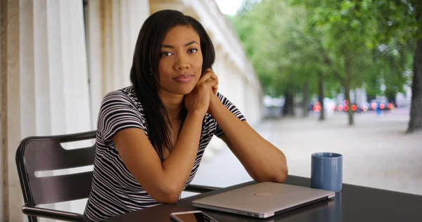 Happy black business woman with laptop finishing her work and smiling at camera