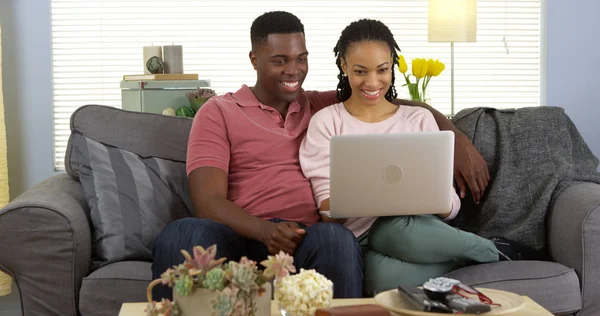 Szczęśliwa Para Czarny Kanapie Podczas Przeglądania Internetu Komputera Przenośnego — Zdjęcie stockowe