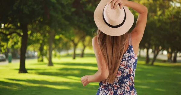 Tiro Traseiro Mulher Segurando Chapéu Enquanto Sente Vento Fora Parque — Fotografia de Stock