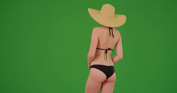 年轻女子在绿色屏幕上戴太阳帽和比基尼的后视 — 图库照片