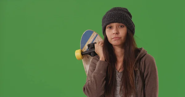 休闲年轻的女性滑板与板摆在绿色屏幕上 — 图库照片