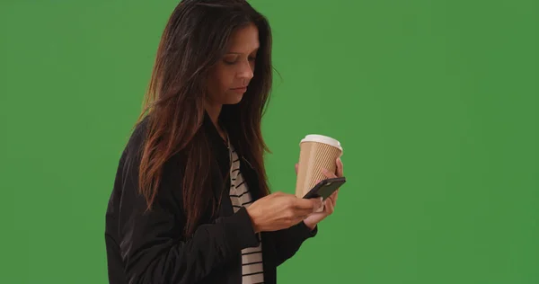 代の美しい女性緑色の画面の上にコーヒー カップを保持しているテキスト メッセージ — ストック写真