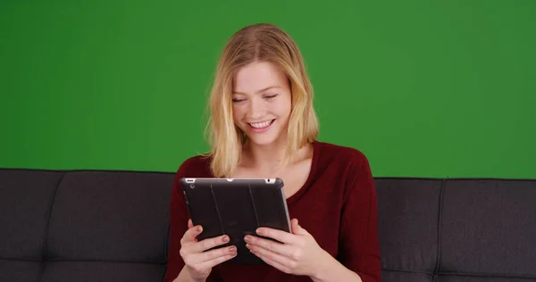 緑色の画面でパッド デバイスを使用しながら笑う美しい白人女性 — ストック写真