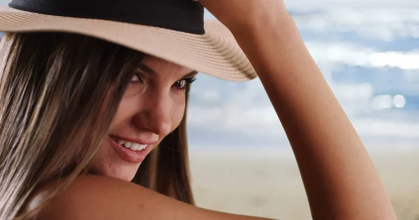 在阳光明媚的海滩环境中 头戴帽子的妇女特写镜头 从她的肩膀上看过去 — 图库照片