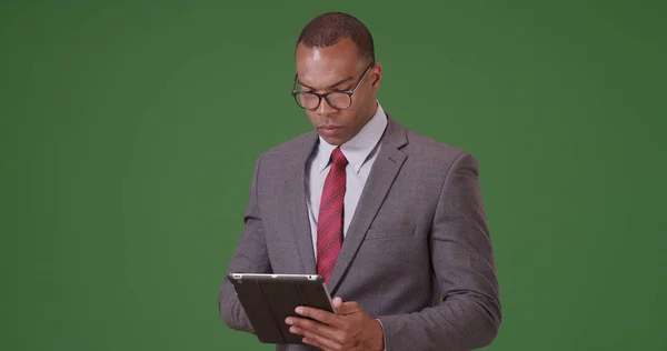 一名黑人商业专业人士在绿屏上的平板电脑上工作 — 图库照片