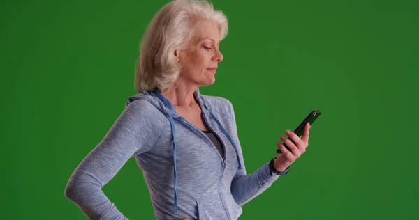 成熟的白种人妇女在智能手机上发短信在绿色屏幕上 — 图库照片