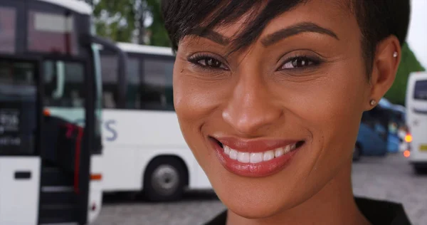 African woman in Paris France looking at camera happily at tour bus stop