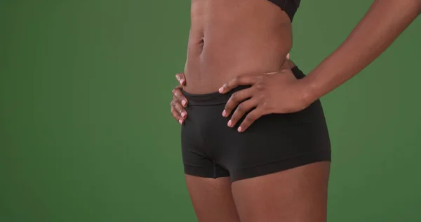 Close up of fit young black woman\'s flat stomach on green screen