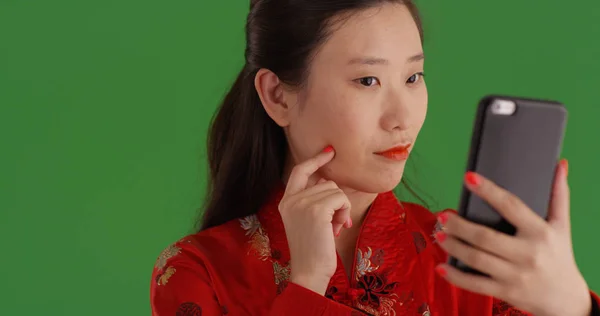 Selfies 緑色の画面にスマート フォンを使用して伝統的な摩耗でアジアの女性 — ストック写真
