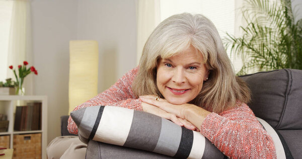 Старшая женщина улыбается в камеру
