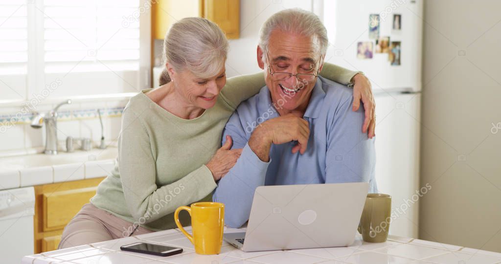 Senior couple using laptop computer in kitchen