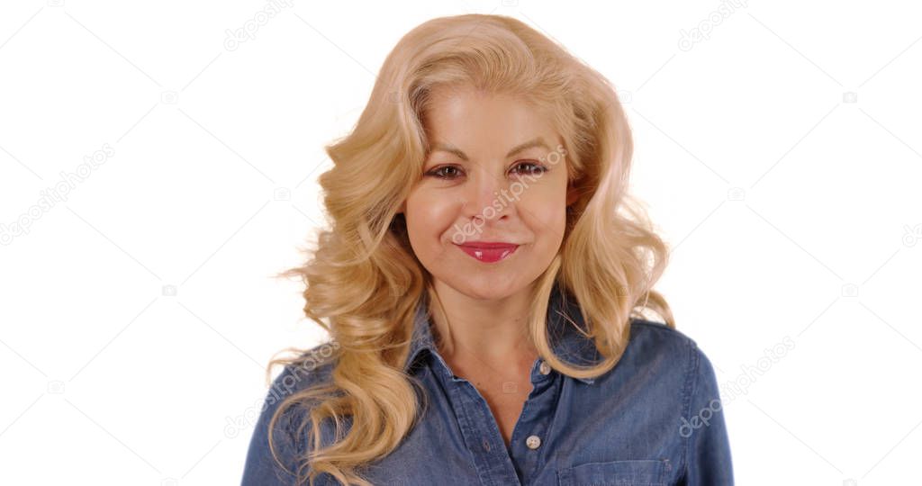 Close up of woman in denim shirt smiling at camera in studio with copyspace
