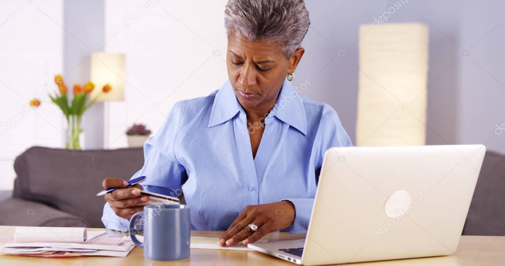 Mature African woman paying her bills
