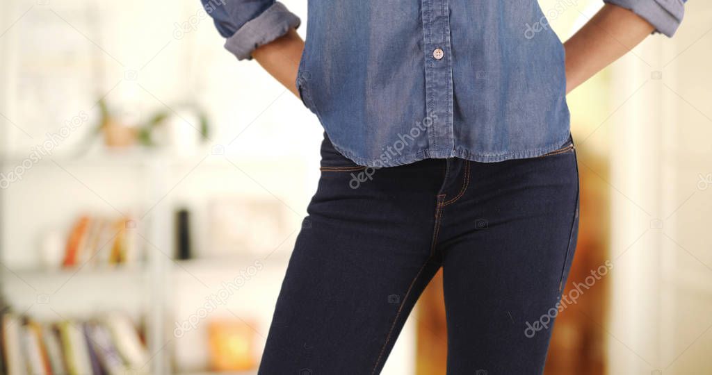 Close up of Caucasian woman putting her hands in front jean pockets at home 