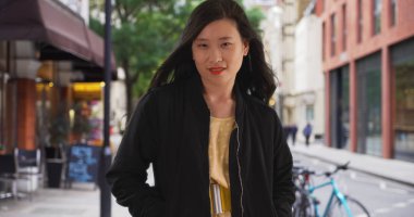 Bombardıman ceket ile caddenin üzerinde bin yıllık Çinli kadın ceplerinde eller