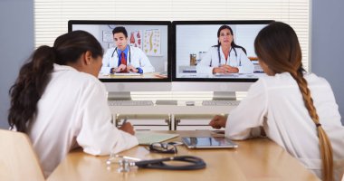 Mixed race team of medical doctors having a video conference clipart