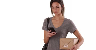 Düz beyaz arka plan üzerinde posta paket tutarken cep telefonu kullanan kadın