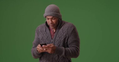 Afro-Amerikan erkek bere ve kazak manifatura telefon yeşil ekran üzerinde