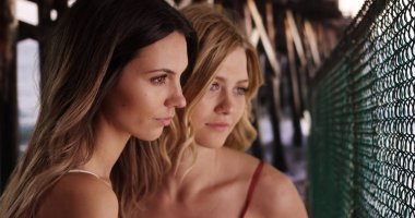 Yakın çekim portre sakin plaj ayarında poz iki güzel beyaz kadın