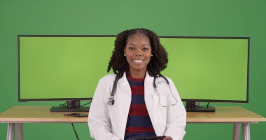 Yeşil ekran bilgisayarlar tarafından oturma emin siyah kadın tıbbi profesyonel