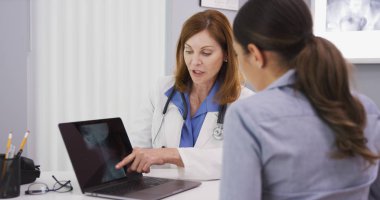 Kıdemli Doktor kafatası ve omurga boyun XRAY genç kadın hastaya gösterilen