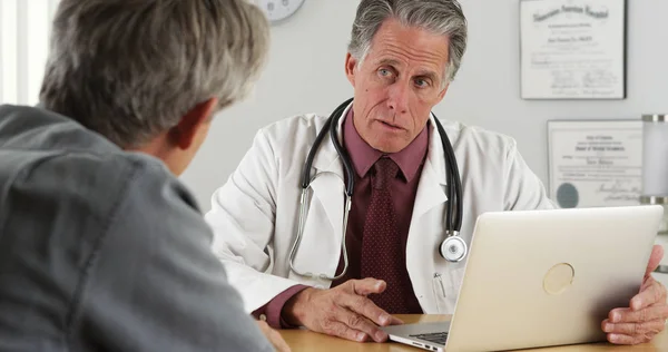 デスクで話している医師と高齢の患者 — ストック写真