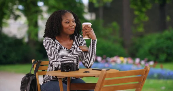Счастливая Чернокожая Женщина Сидит Столом Прекрасном Парке Брюгге Пьет Кофе — стоковое фото