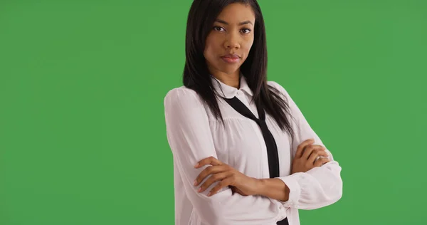 Confident African American professional woman with arms crossed on green screen