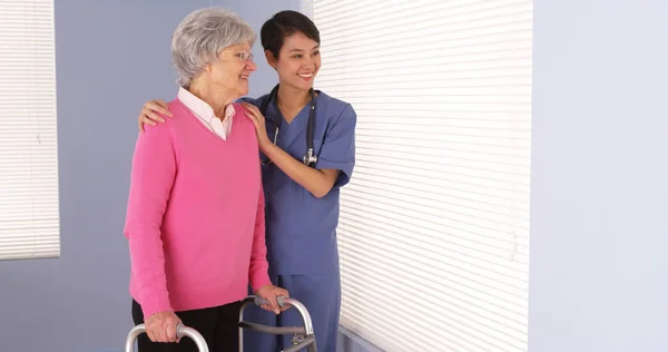 Azjatycka Pielęgniarka Starszych Pacjentów Stojących Przez Okno — Zdjęcie stockowe