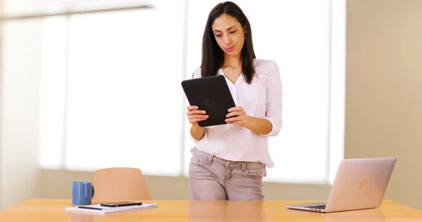 A Latina businesswoman uses her tablet