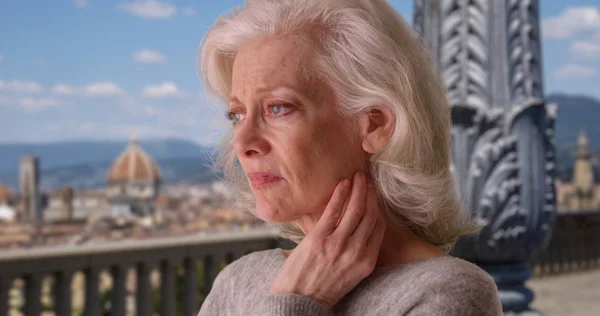 Sad depressed older woman looking at florence skyline in the day