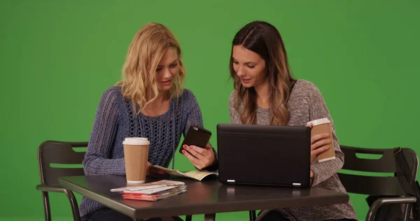 Beautiful young women using tech to locate destination on map over greenscreen