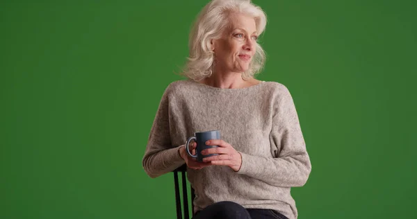 Oudere Vrouw Zit Met Koffie Met Peinzende Uitdrukking Groen Scherm — Stockfoto