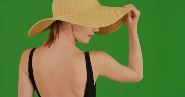 时尚的千禧一代妇女在绿色屏幕上戴太阳帽的后视 — 图库照片
