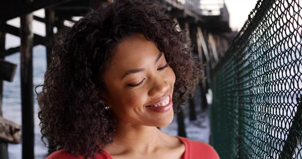 Onnellinen Nuori Afrikkalainen Nainen Hymyilee Itsekseen Rauhallisella Rannalla Laiturin Alla — kuvapankkivalokuva