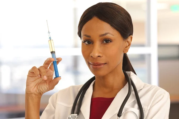 Closeup of young African doctor holding medical injection for vaccination