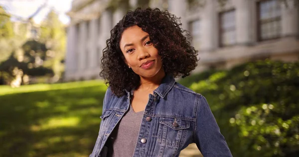Independent young African-American woman posing confidently on college campus