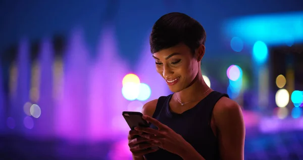 Улыбающаяся Молодая Черная Женщина Пишет Смс Мобильный Телефон Красочный Фонтан — стоковое фото