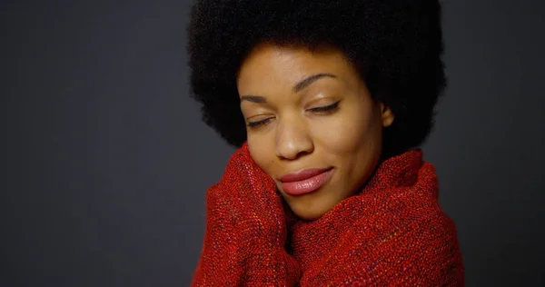 Black woman with afro wearing red shawl