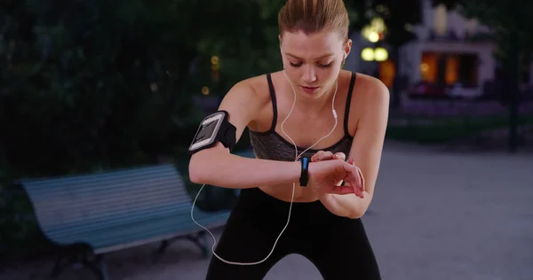 Tired woman jogger on night run stopping to breathe