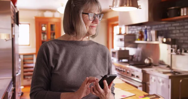 Happy Senior Woman Sending Text Messages Domestic Kitchen Setting — Stock Photo, Image