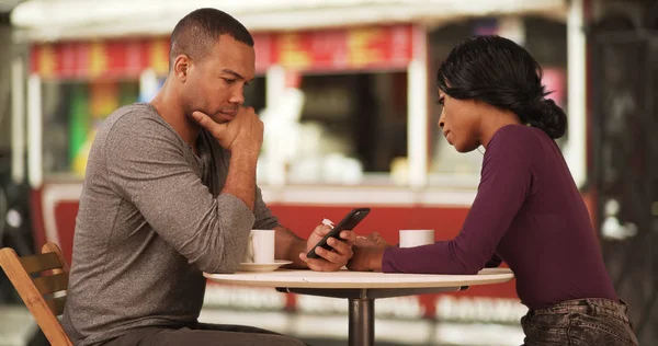 黑人夫妇喝咖啡和浏览互联网上的智能手机约会 — 图库照片