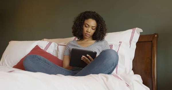 若い魅力的な黒ベッド女性読書タブレット — ストック写真