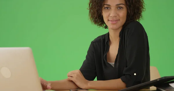 Чернокожая Женщина Ноутбука Смотрит Камеру Своего Стола Зеленом Экране — стоковое фото