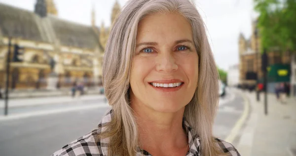 Caucasian female in London street smiles with joy