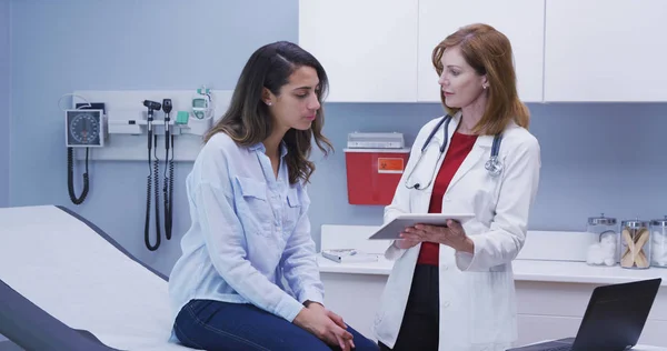 Lovely young latina patient consulting with doctor about health condition