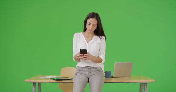 一位拉丁女商人用她的智能手机在绿屏上发短信 — 图库照片